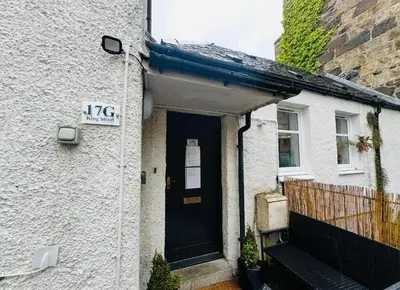 a house with a black door with a sign on it at Cosy Hideaway in Stirling
