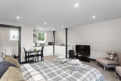 a bedroom with a bed and a living room at Large Edinburgh Studio - Close to City Centre, Murrayfield and Airport in Edinburgh