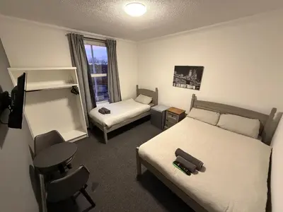 a bedroom with a bed and a desk and a chair at The Woodside in Cowdenbeath