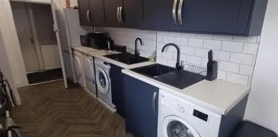 a kitchen with a sink and a washing machine at The Woodside in Cowdenbeath