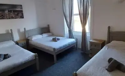 a room with two twin beds and a window at The Woodside in Cowdenbeath