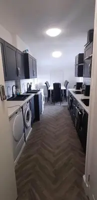a room with a kitchen with a table and chairs at The Woodside in Cowdenbeath