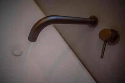 a shower head with a pipe in a bathroom at The Shore House in Lamlash