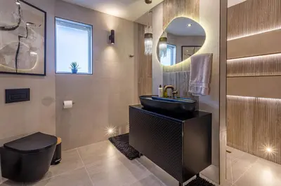 a bathroom with a sink and a toilet and a mirror at The Shore House in Lamlash