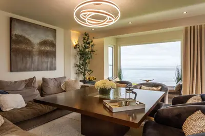 a living room with a table and a large window at The Shore House in Lamlash