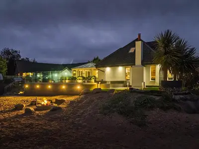 a house with a fire in front of it at night at The Shore House in Lamlash