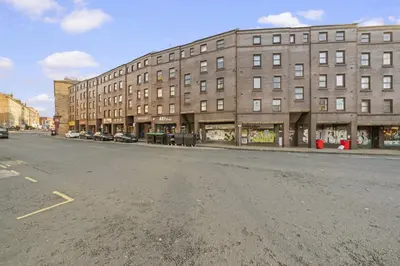 an empty street in front of a large brick building at Lauriston 1 Bedroom Apartment - Edinburgh in Edinburgh