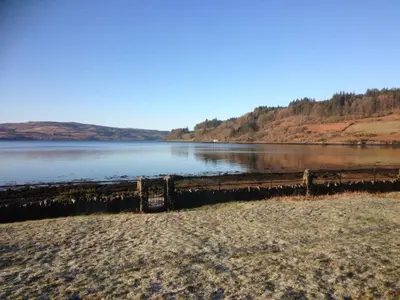 a view of a body of water with a wooden fence at Kilfinichen Church in Kilfinchen