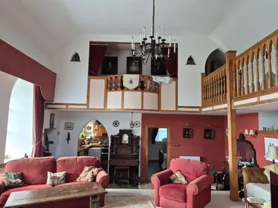 a living room with two red chairs and a staircase at Kilfinichen Church in Kilfinchen