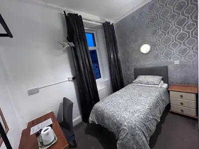a small bedroom with a bed and a window at Glendale Guesthouse in Oban