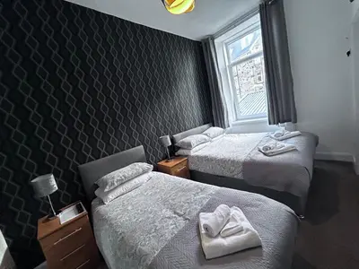 a hotel room with two beds and a window at Glendale Guesthouse in Oban