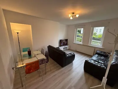 a living room with a couch and a table at Glasgow 2 Bedroom Apartment Access To City Centre in Gartcosh