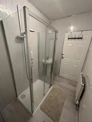 a bathroom with a glass shower and a toilet at Glasgow 2 Bedroom Apartment Access To City Centre in Gartcosh
