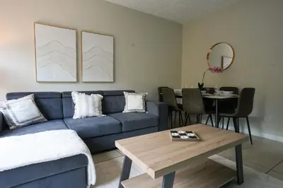 a living room with a blue couch and a table at Stobhill Apartment in Glasgow