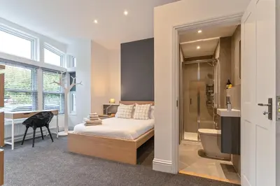 a bedroom with a bed and a walk in shower at Faulkner Luxury Suites in Moffat