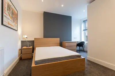a small bedroom with a bed and a desk at Faulkner Luxury Suites in Moffat