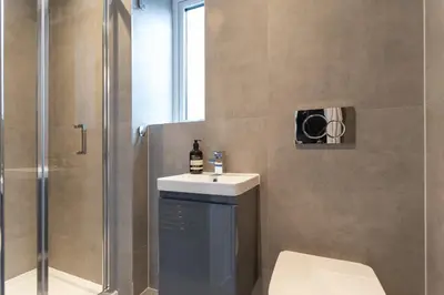 a bathroom with a shower and a sink and a toilet at Faulkner Luxury Suites in Moffat