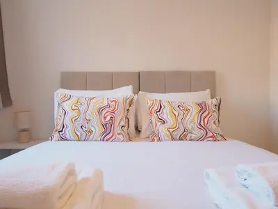 a bedroom with a bed with two colorful pillows at Fettes - Homely 2BD in Quiet Development in Edinburgh