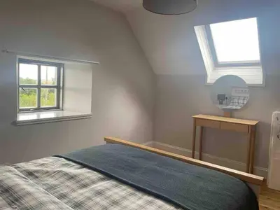 a bedroom with a bed with a mirror and a window at Linlithgow cottage close to Edinburgh in Linlithgow
