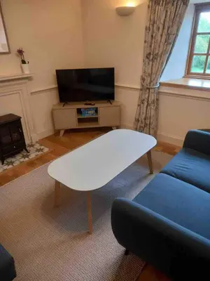 a living room with a white coffee table and a tv at Linlithgow cottage close to Edinburgh in Linlithgow
