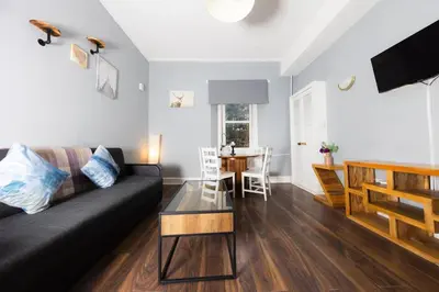 a living room with a black couch and a table at Stylish and Unique Apartment by the Meadows 8 in Edinburgh