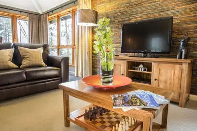 a living room with a television and a table with a chessboard at 2 Bedroom detached lodge overlooking Loch Lomond in Balloch