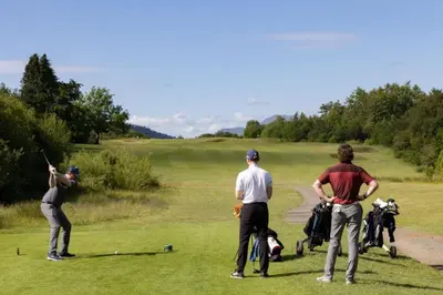 a group of men playing golf on a golf course at 2 Bedroom detached lodge overlooking Loch Lomond in Balloch