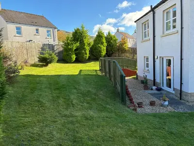 a yard with a fence and a house at Westcoast-Retreat-Largs in Largs