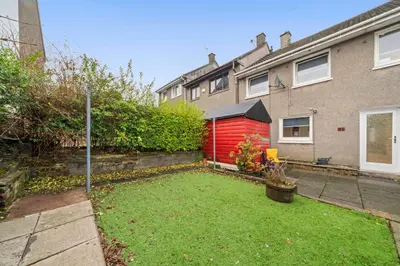 a yard with a red shed in front of a house at The Elphin Escape in East Kilbride
