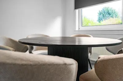 a table and chairs in a room with a window at The Elphin Escape in East Kilbride