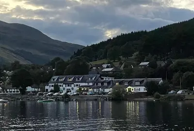 a group of houses on the shore of a body of water at The Clachan Hotel, Lochearnhead in Lochearnhead
