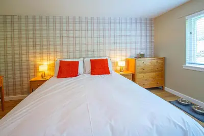 a bedroom with a large white bed with two red pillows at The Clachan Hotel, Lochearnhead in Lochearnhead