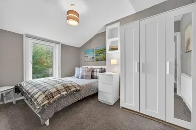 a bedroom with a bed and a window at Coastal Charm: Modern Retreat by Seafront in Largs