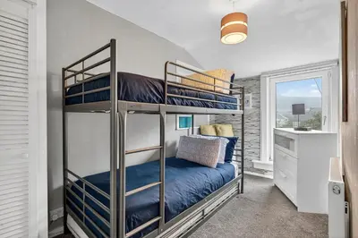 a bedroom with two bunk beds in a room at Coastal Charm: Modern Retreat by Seafront in Largs