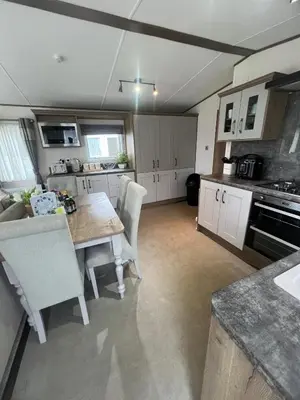 a kitchen with a table and chairs in a room at Wemyss Bay Beaumont Elite in Skelmorlie