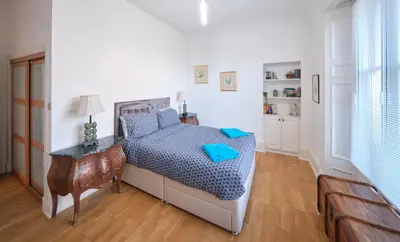 a bedroom with a bed with a blue comforter at Bruce on the Row-Historic Elegance near Edinburgh by Urban Haggis Stays in Dunfermline