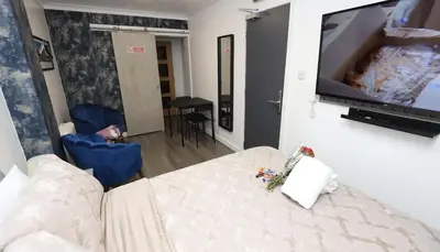 a living room with a couch and a flat screen tv at Glasgow Studio in Glasgow
