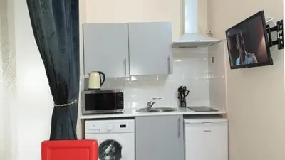a small kitchen with a microwave and a washer at Glasgow Studio in Glasgow