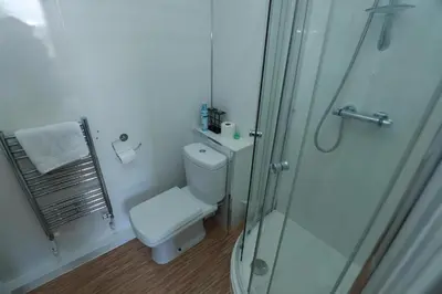 a bathroom with a toilet and a glass shower at Glasgow Studio in Glasgow