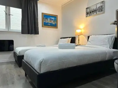 a bedroom with two beds and a television in it at Glasgow Studio in Glasgow