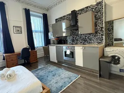 a room with a kitchen with a bed and a sink at City Centre Studio - Charing Cross in Glasgow