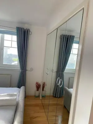 a bedroom with a mirror and a bed and a couch at Seaview Retreat in Troon