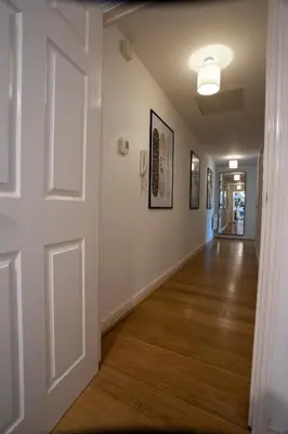 an empty hallway with a white door and wood floors at Modern 2-Bed Flat, Sleeps 6, Near Gosforth in Moffat