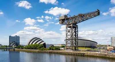 a crane next to a body of water with buildings at Modern&Stylish city centre apartment with parking in Glasgow