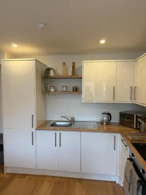 a kitchen with white cabinets and a sink at Modern&Stylish city centre apartment with parking in Glasgow