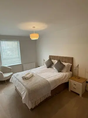 a bedroom with a large bed and a chair at Modern&Stylish city centre apartment with parking in Glasgow