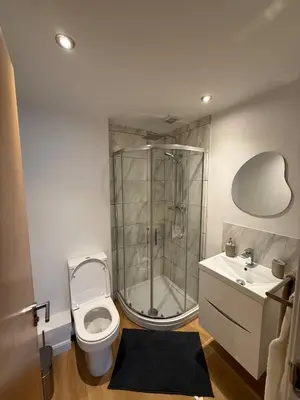 a bathroom with a shower and a toilet and a sink at Modern&Stylish city centre apartment with parking in Glasgow