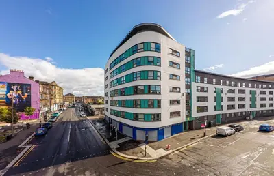 a tall white building on a city street at Modern&Stylish city centre apartment with parking in Glasgow