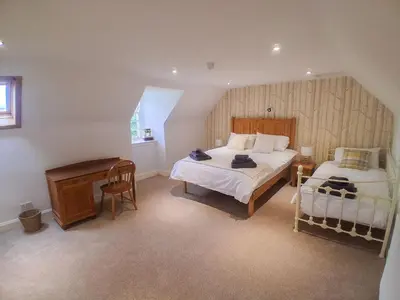 a bedroom with two beds and a desk in it at Hillside House in Dunfermline