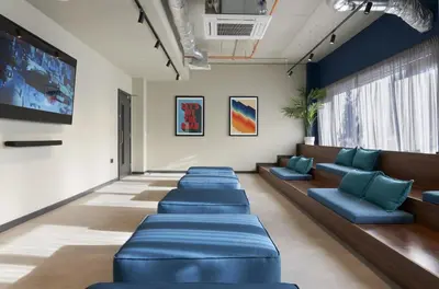 a waiting room with blue couches and a tv at For Students Only Westfield in Edinburgh in Edinburgh